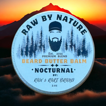 Load image into Gallery viewer, Beard butter balm container with 'Raw by Nature' branding against a mountain and sunset background.