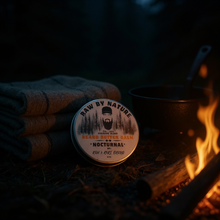 Load image into Gallery viewer, Beard Balm labeled 'Raw by Nature' next to a campfire.