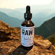 Load image into Gallery viewer, A bottle of Raw By Nature Beard Oil with a mountain in the background