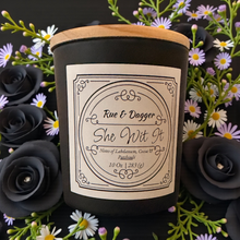Load image into Gallery viewer, Candle with a label surrounded by flowers and black roses
